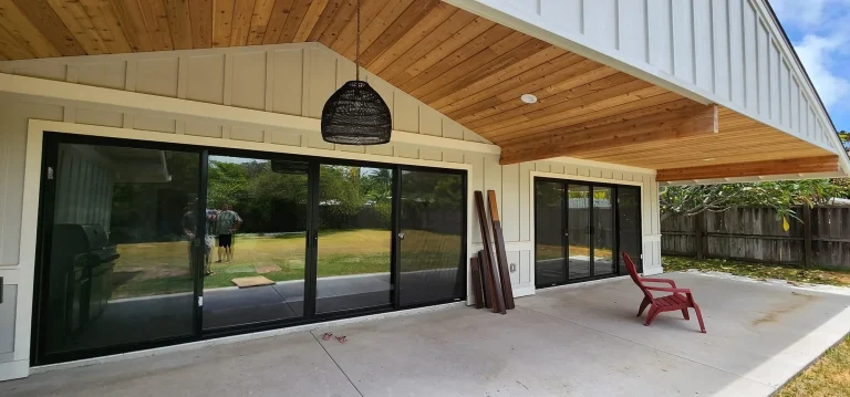 Covered lanai with tongue-and-groove wood ceiling and large sliding glass doors opening to the yard