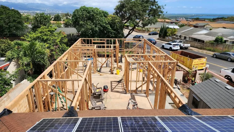 Aerial view of new wall framing on a residential lot with neighborhood and ocean in the distance