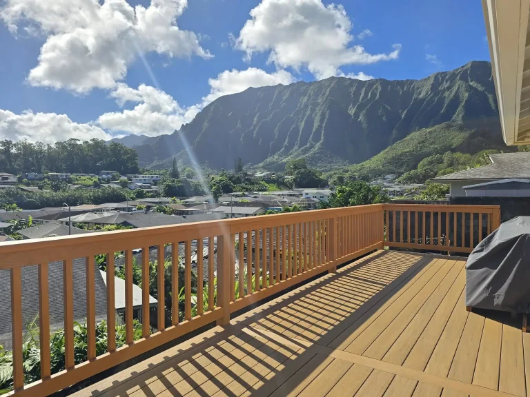 New wood deck and railing overlooking a neighborhood and green mountains